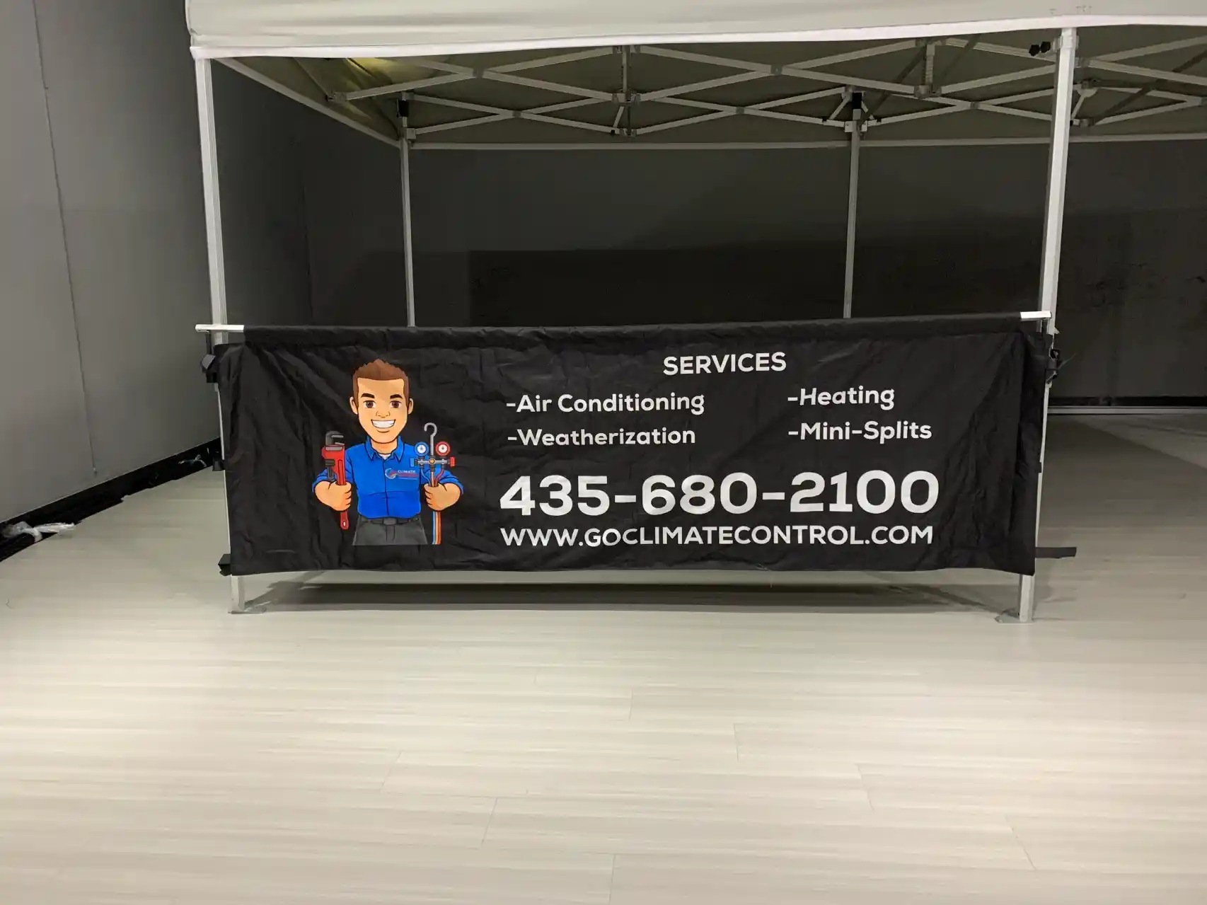 Climate Control 10x10 booth interior with branded side banner attached to the tent frame